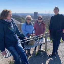 Vier Frauen rasten bei einer Bank (Bewegen, Begegnen – gemeinsam unterwegs)